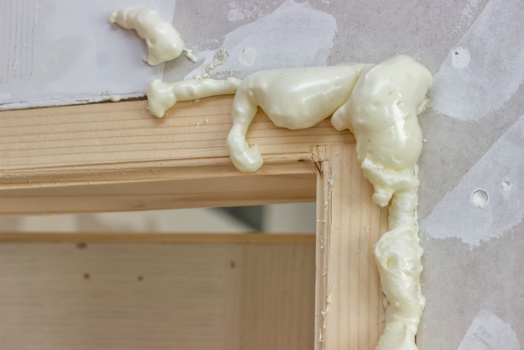 Polyurethane foam sprayed around door frame